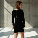 Woman wearing a black dress with a zipper detail on a gray background