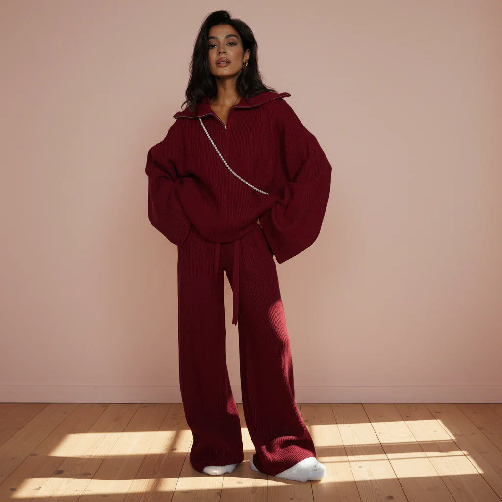 Person wearing a burgundy outfit with a matching jacket and pants on a gray background