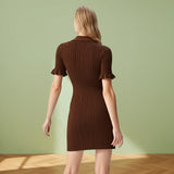 Woman wearing a brown ribbed dress against a gray background