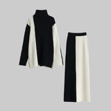 Black and white turtleneck sweater and skirt set on a light gray background