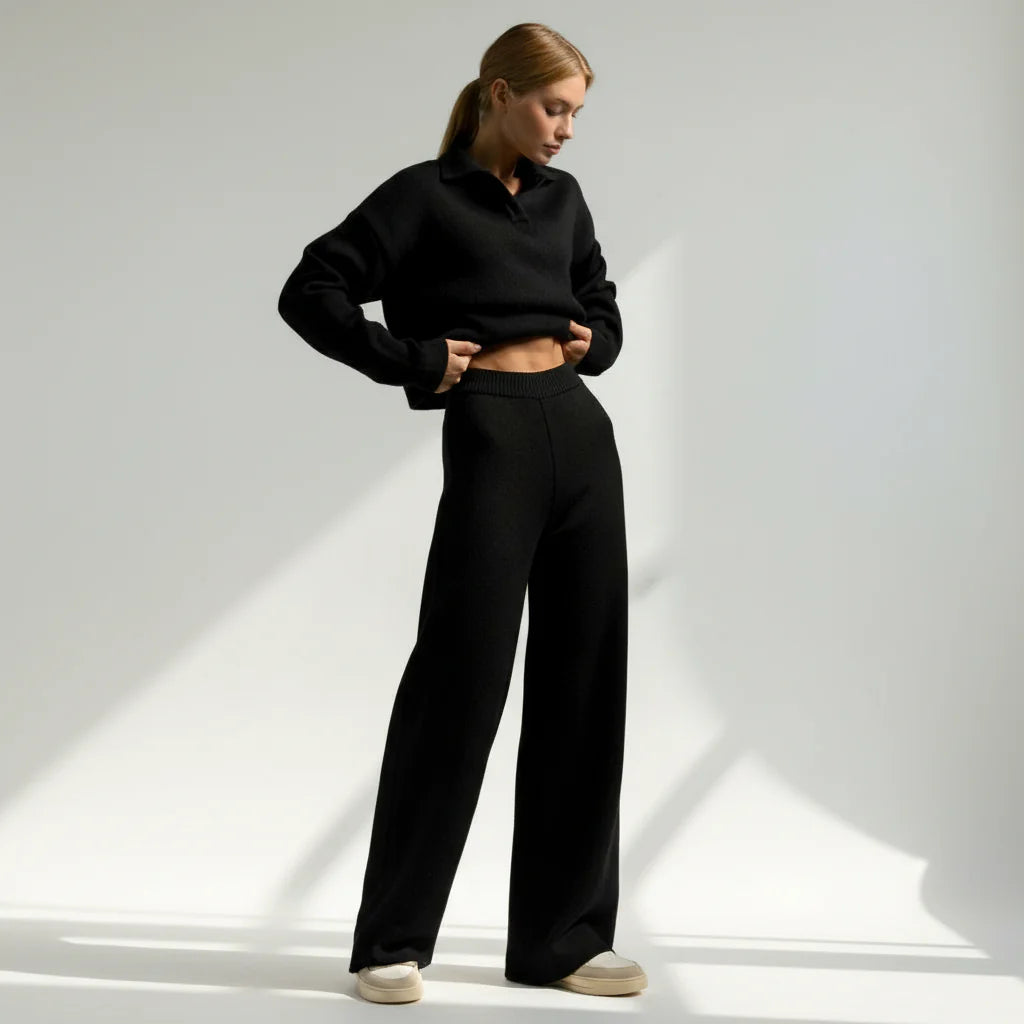 Person wearing a black outfit on a light gray background