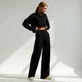 Person wearing a black outfit on a light gray background