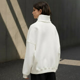 Person wearing a white sweater on a gray background