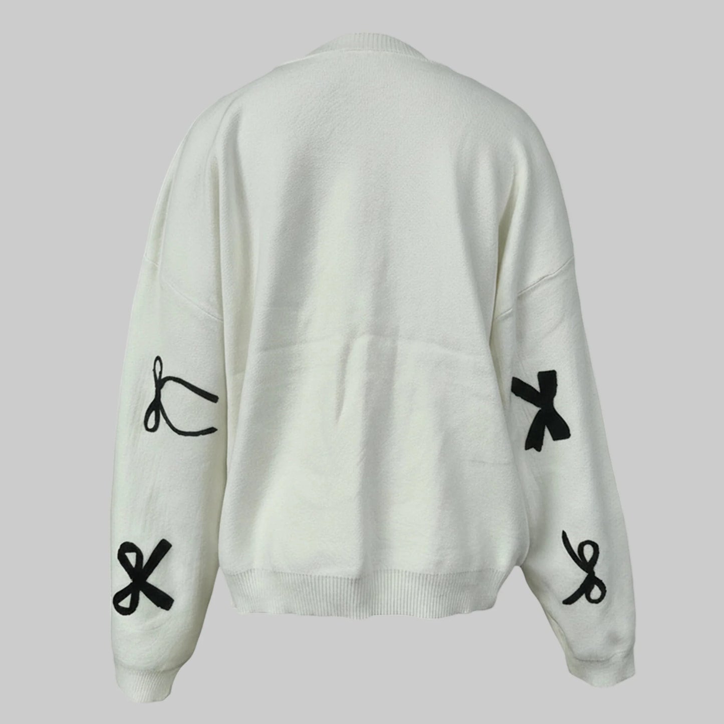 White sweater with black symbol designs on a light gray background