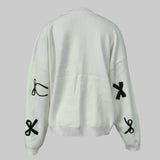 White sweater with black symbol designs on a light gray background