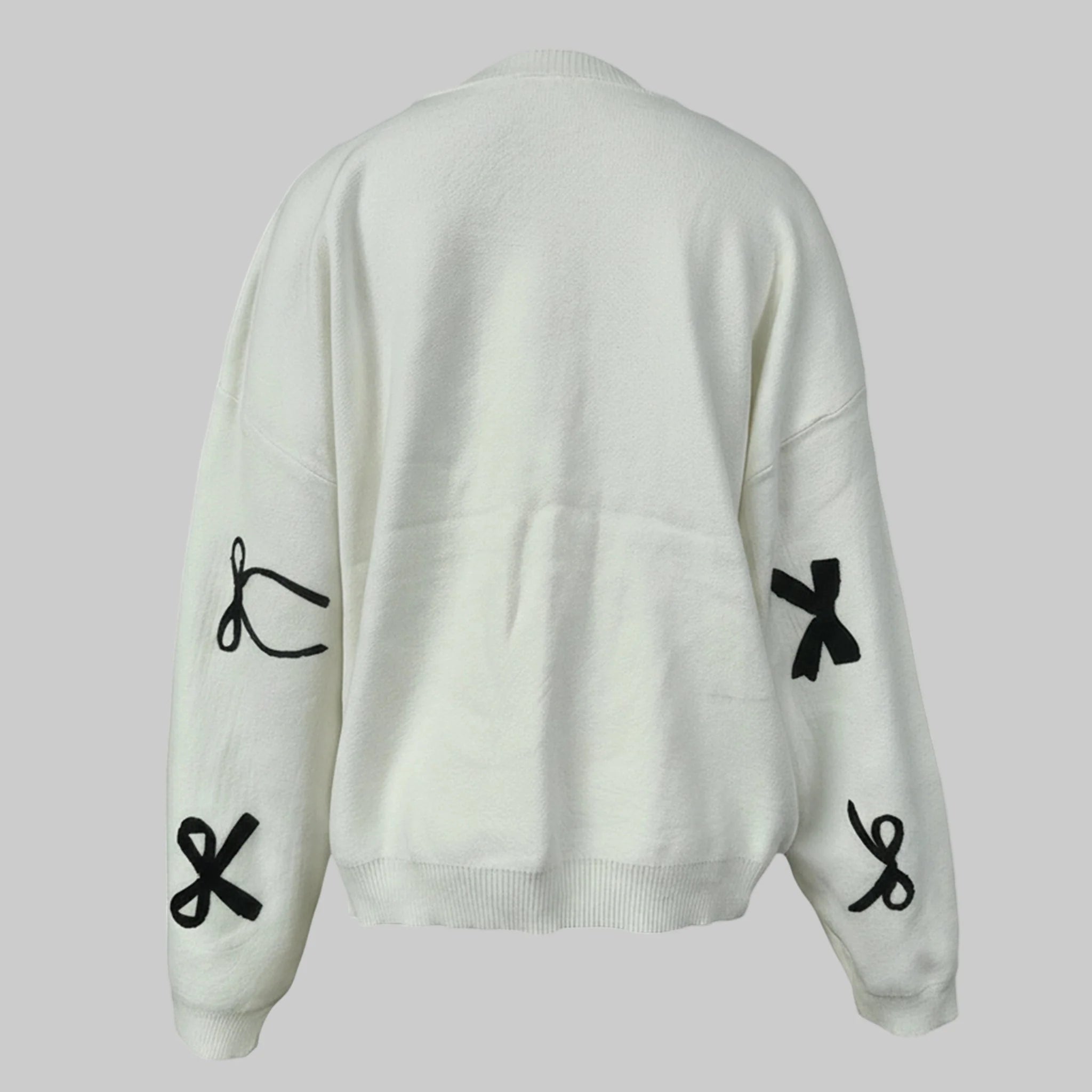 White sweater with black symbol designs on a light gray background