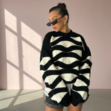 Woman wearing a black and white striped sweater with sunglasses indoors.