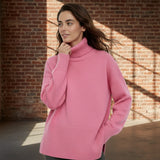 Woman wearing a pink sweater on a plain background