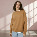Woman wearing a brown sweater on a gray background