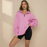 Woman wearing a pink oversized sweatshirt and black shorts on a gray background