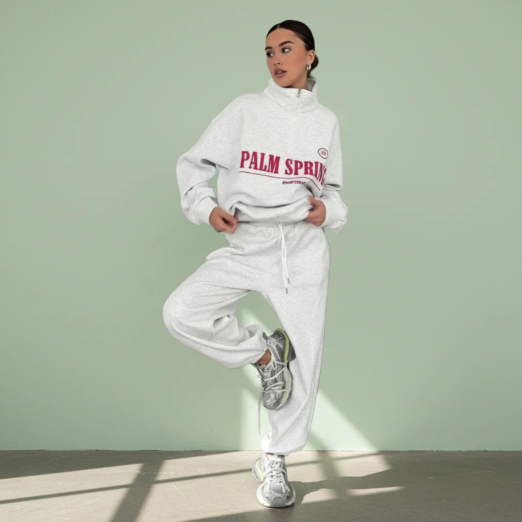 Person wearing a white hoodie with 'Palm Springs' text on a gray background