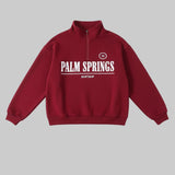 Red sweatshirt with 'Palm Springs' text on a white background
