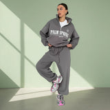 Person wearing a gray 'Palm Spring' tracksuit on a light gray background
