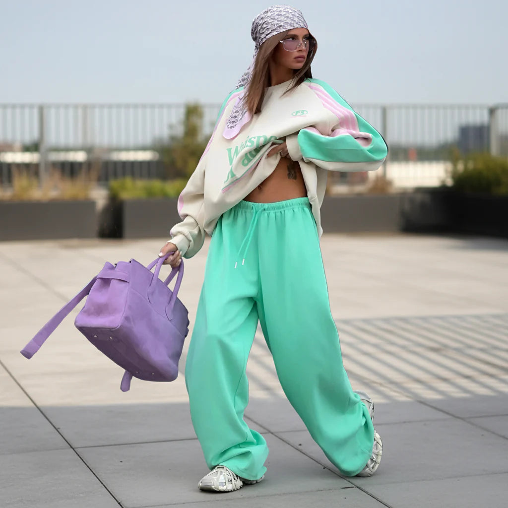 Person wearing a stylish outfit with a purple bag on a city street.