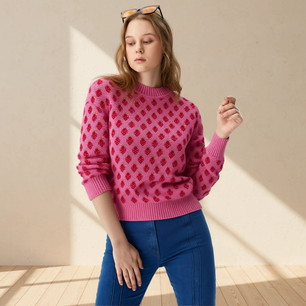 Woman wearing a pink sweater with red pattern and blue jeans on a gray background