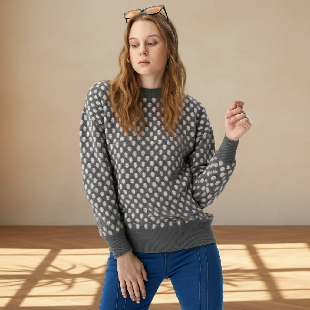 Woman wearing a patterned sweater and blue pants in a well-lit room.