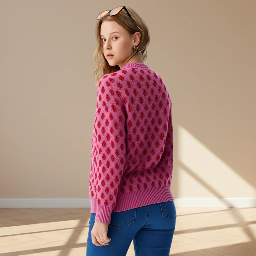 Woman wearing a pink sweater with red pattern on a gray background