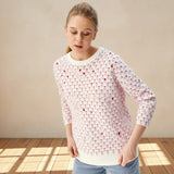 Person wearing a pink patterned shirt on a gray background