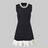Black dress with white trim on a white background