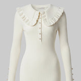White ribbed dress with ruffled collar and button details on a white background